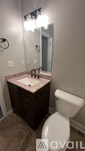 A bathroom with a sink, toilet and mirror.