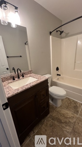 A bathroom with a sink, toilet, and bathtub.