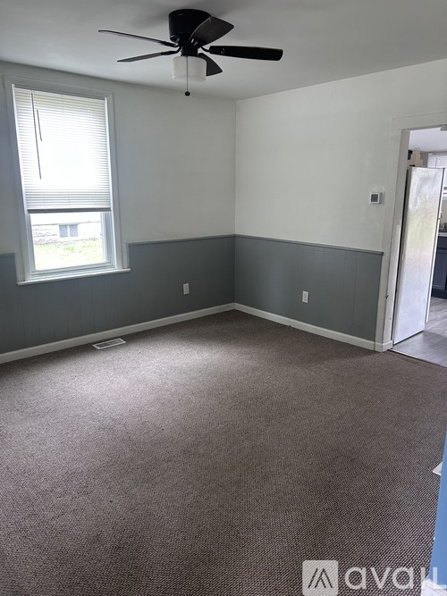 A room with a ceiling fan and a window.