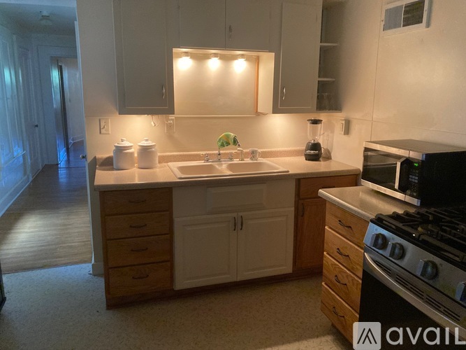 A kitchen with white cabinets and a black stove top oven.