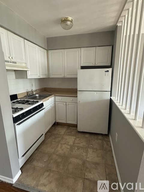 A kitchen with white appliances and cabinets.