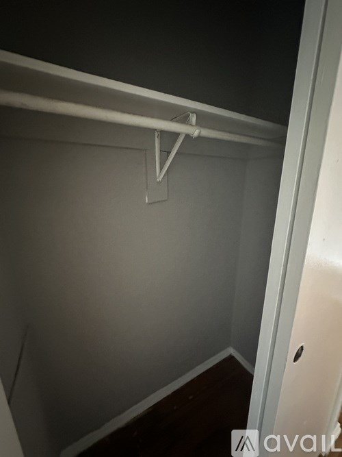 A white closet with a hanger on the rod.