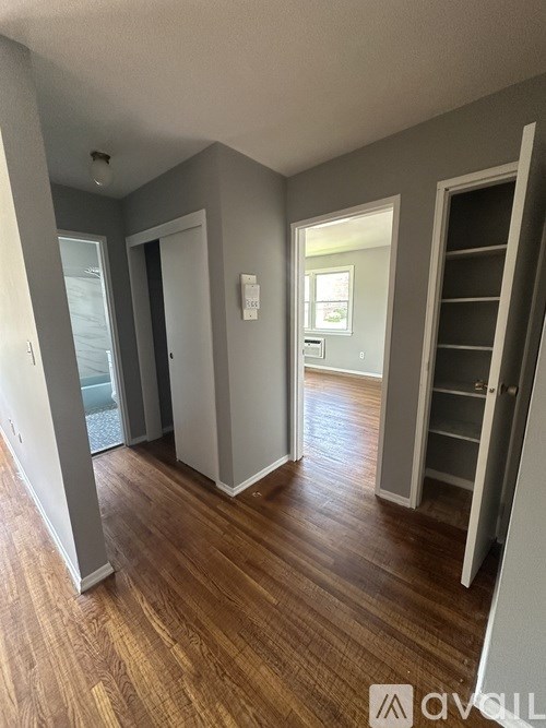 A hallway with a wooden floor and white walls.