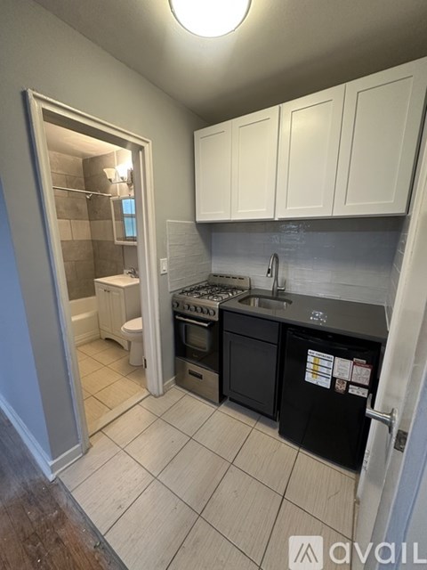 A small kitchen with black appliances and white cabinets.