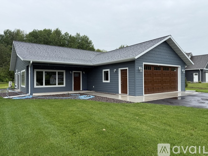 A blue house with a grey roof and a garage door.