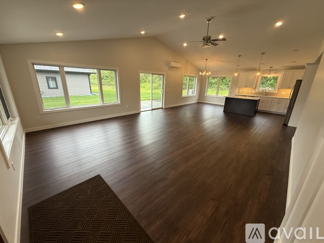 A spacious living room with wood flooring and a ceiling fan.