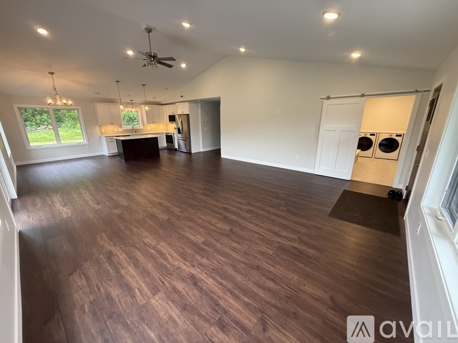 A spacious room with wooden flooring and a ceiling fan.