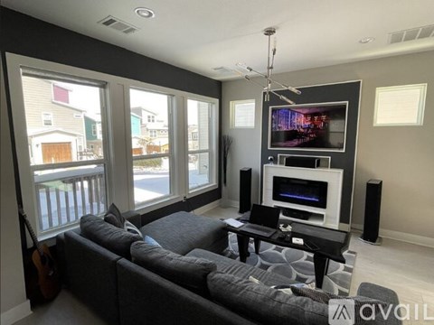 A living room with a grey couch and a television.