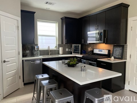 A kitchen with a white countertop and black cabinets.