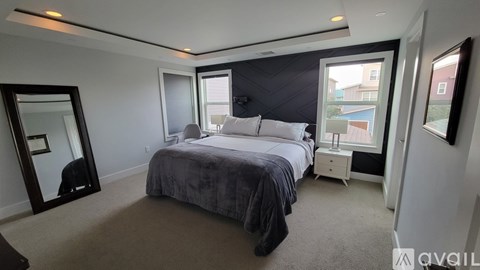 A bedroom with a large bed and a large mirror on the wall.