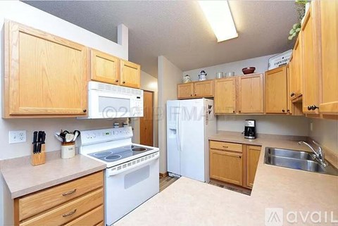 A kitchen with wooden cabinets and white appliances.