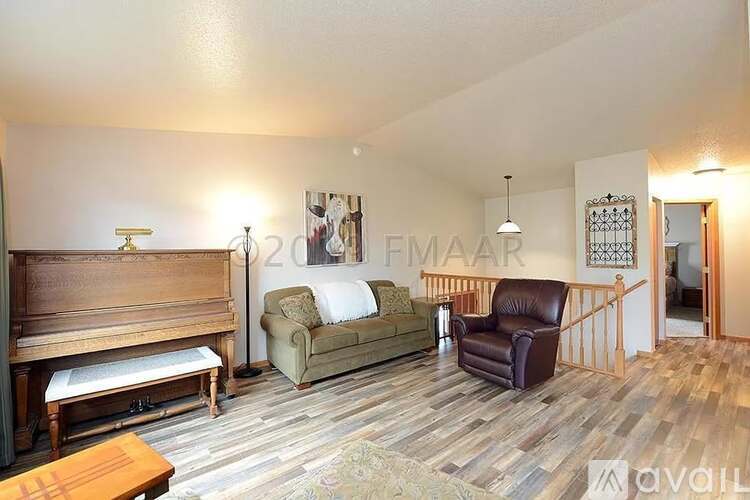A living room with a couch, chair, and a wooden bench.