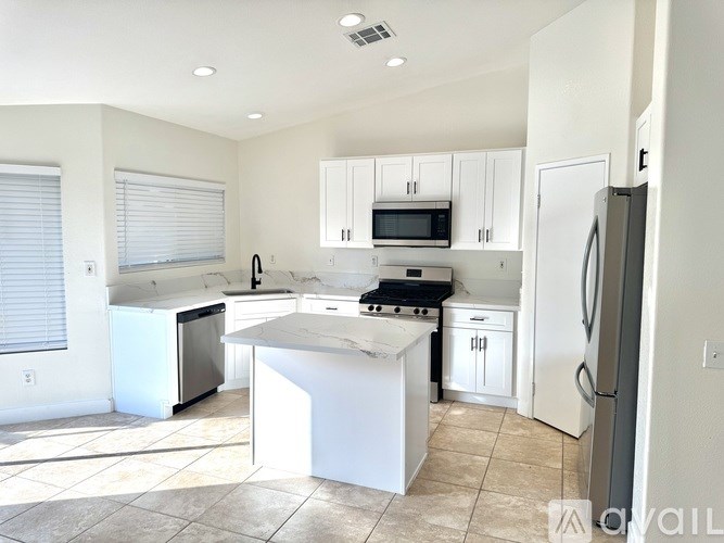 A kitchen with white appliances and cabinets.