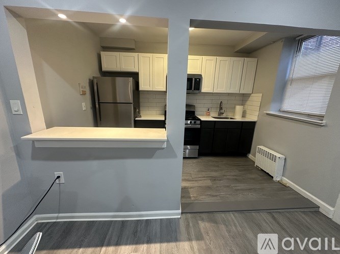 A kitchen with a refrigerator, microwave, and oven.