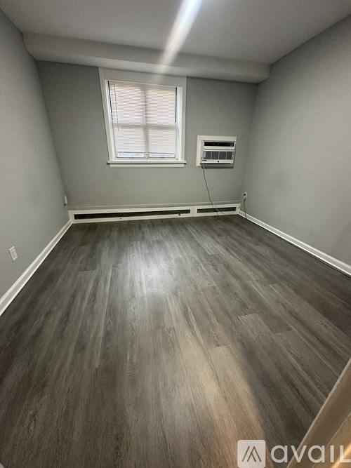A room with wooden flooring and a window.