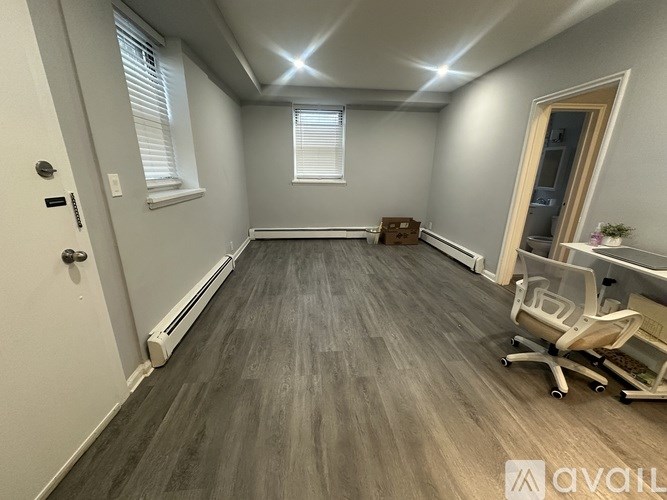 A room with a wooden floor and a desk with a chair.