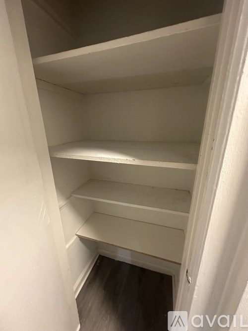 A white closet with shelves and a door.
