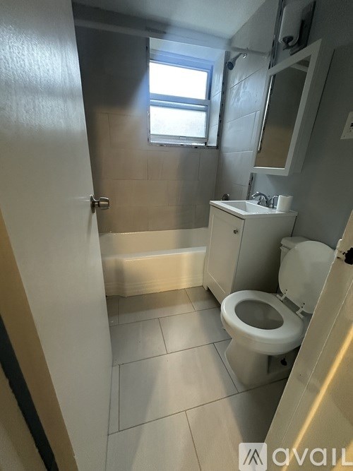 A bathroom with a toilet, sink, and mirror.