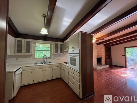 A kitchen with white cabinets and a brick fireplace.