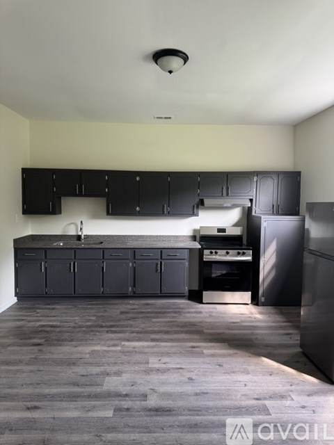 A kitchen with black cabinets and stainless steel appliances.