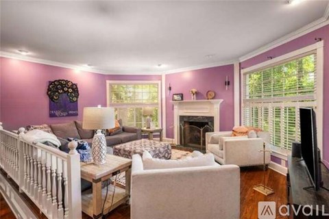 A living room with a white couch and a fireplace.