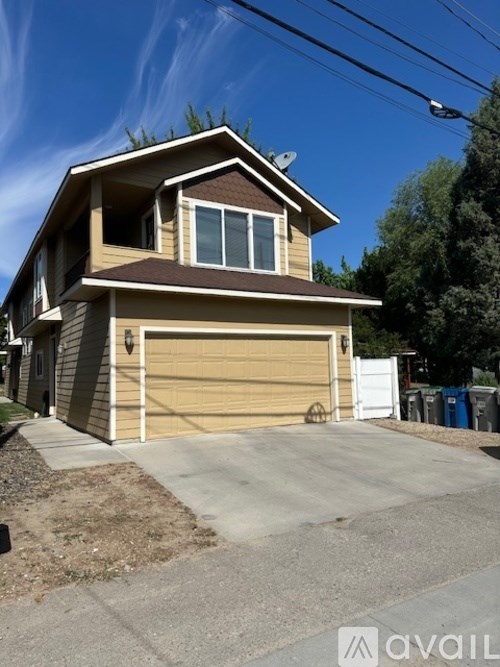 A two-story house with a garage door is for sale.