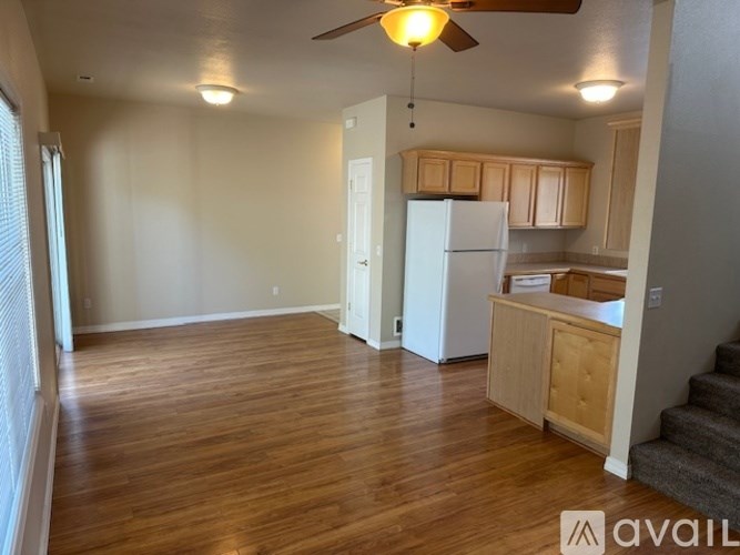 A room with wooden floors and a ceiling fan.