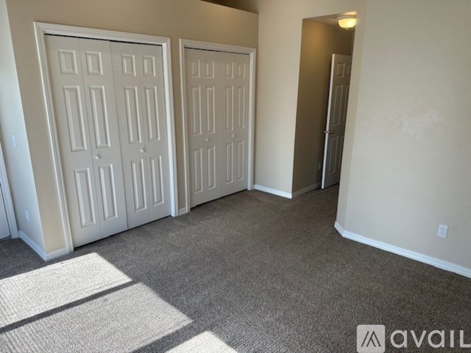 A room with two doors and a carpeted floor.