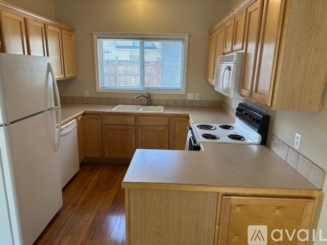 A kitchen with wooden cabinets and a white refrigerator.