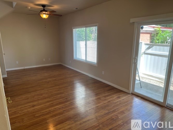 A room with wooden flooring and a ceiling fan.
