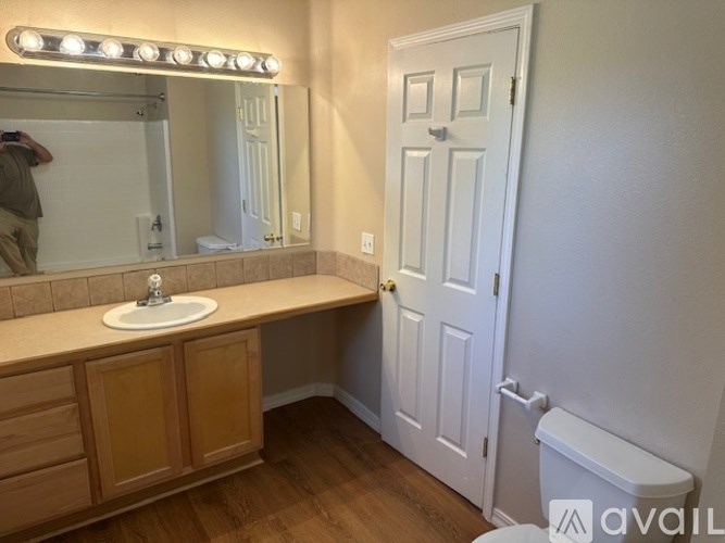 A bathroom with a sink, mirror, and wooden cabinets.