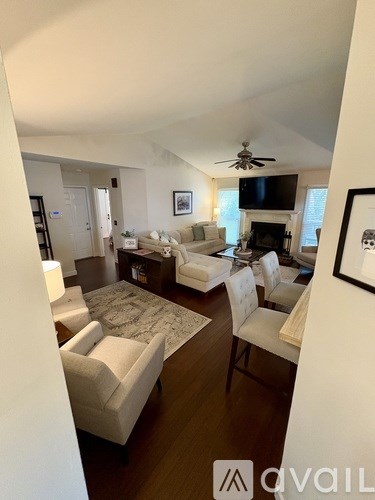 A living room with a white couch and a rug.