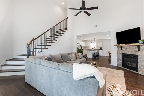 A living room with a grey couch and a fireplace.