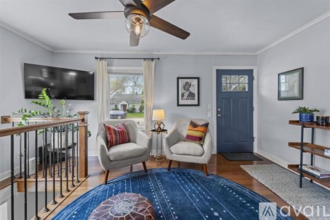 A living room with a blue rug and two chairs.