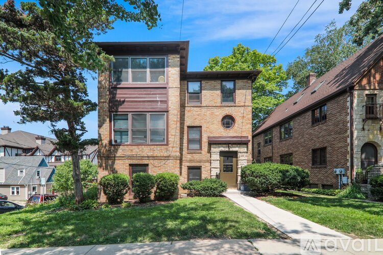 A large house with a brown brick exterior and a white door.