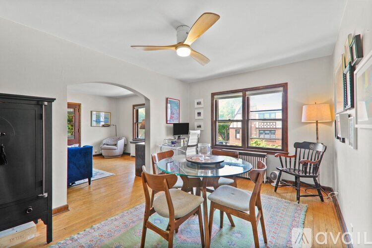A dining room with a table set for four and a fan on the ceiling.