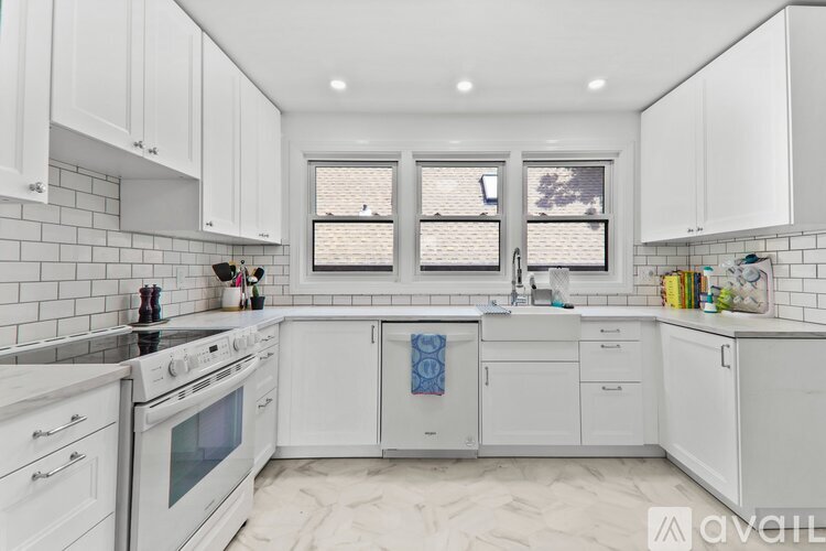 A kitchen with white cabinets and a tile backsplash.
