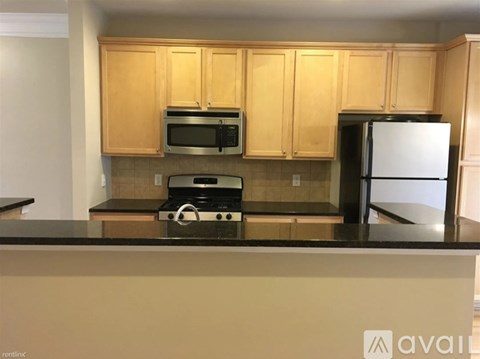 A kitchen with wooden cabinets and a black countertop.