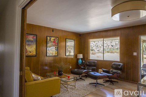 A living room with a yellow couch and a coffee table.