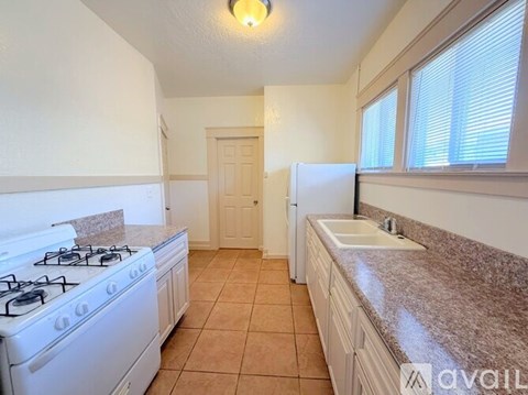 A kitchen with a white stove and a white refrigerator.