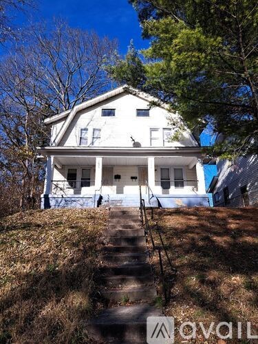 A white house with a staircase leading to the front door.