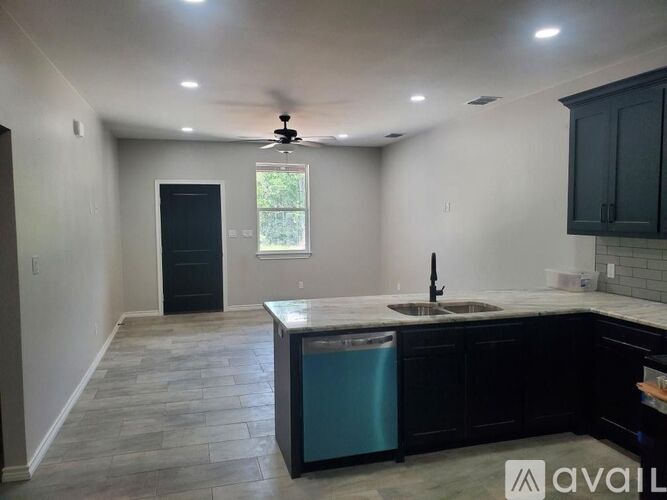 A kitchen with a black fridge and a black door.