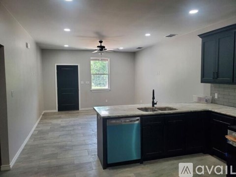 A kitchen with a black fridge and a black door.