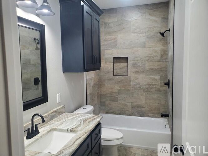 A bathroom with a sink, toilet, and a bathtub.