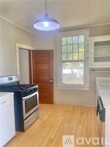 A kitchen with a white stove top oven and a black stove top.