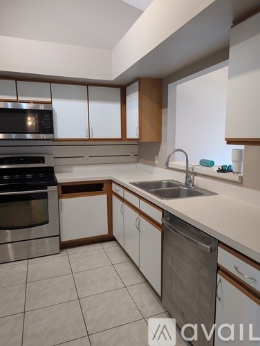 A kitchen with white cabinets and a stainless steel dishwasher.