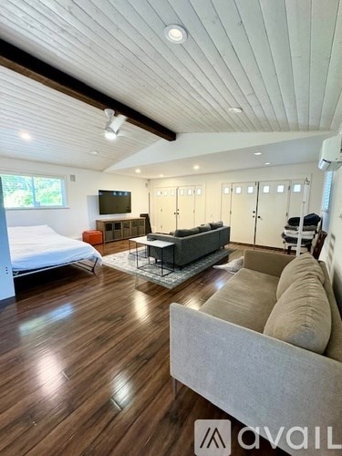 A living room with a grey couch and a wooden floor.