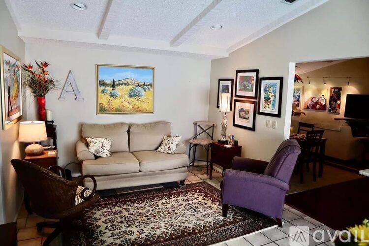 A living room with a couch, chair, and pictures on the wall.