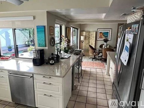 A kitchen with a refrigerator on the right side.