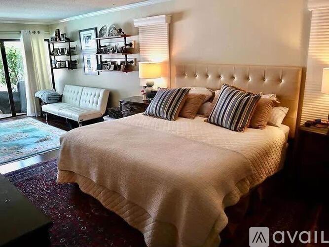 A bedroom with a large bed and a bench.